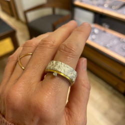 Ring aus Silber und Gold mit Brillant getragen